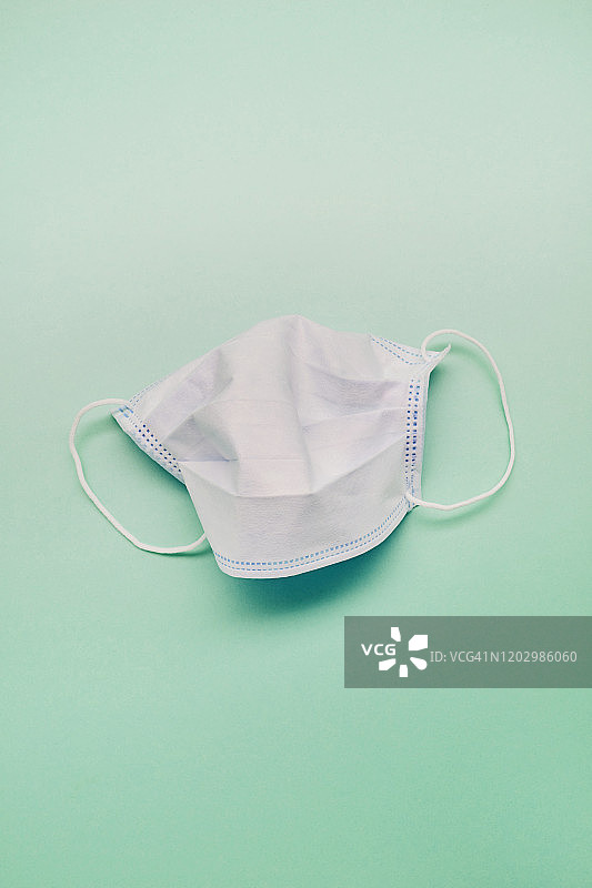 绿色背景上的白色面膜高角度视角图片素材