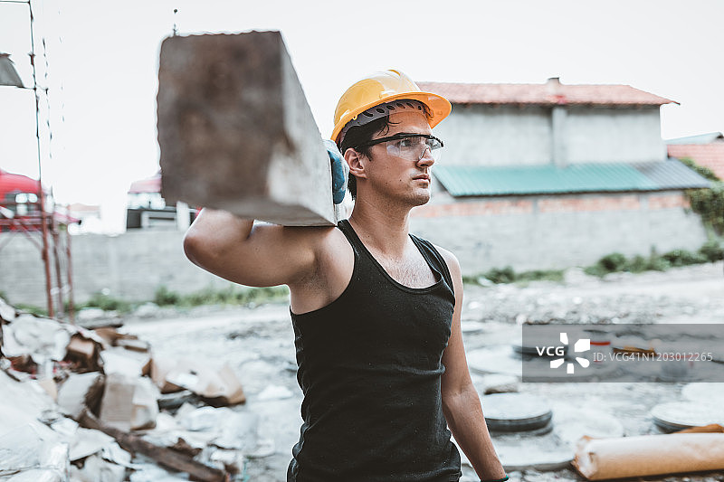 工地现场扛着木板的建筑工人肖像图片素材