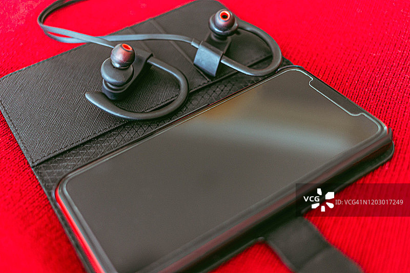 带蓝牙耳机的智能手机皮套特写图片素材