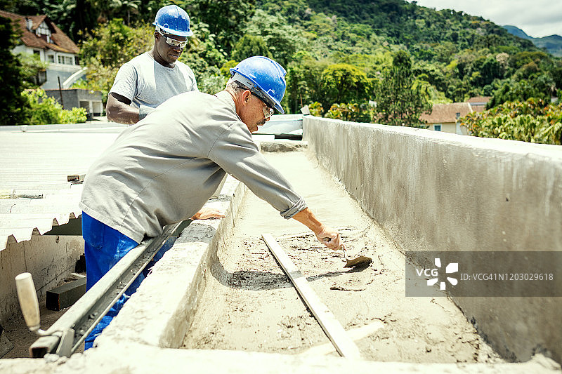 在建筑工地上戴着安全帽工作的男人们图片素材