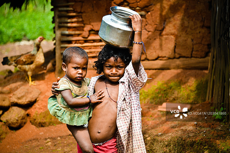 印度小女孩和她的妹妹头顶运水图片素材