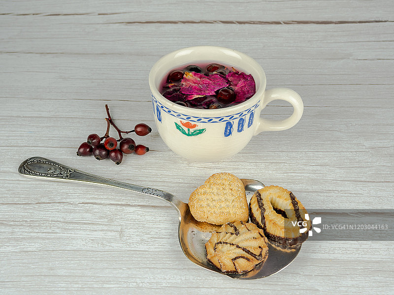 一杯含有药用草本、玫瑰果、山楂和玫瑰花瓣的热饮图片素材