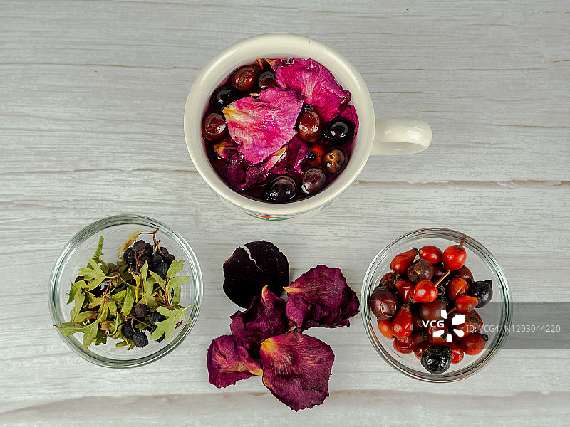一杯含有药用草本、玫瑰果、山楂和玫瑰花瓣的热饮图片素材