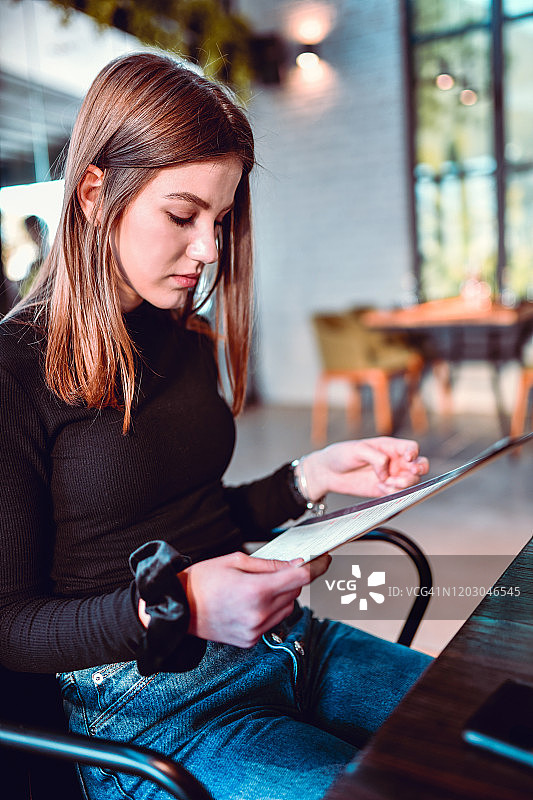 正在查看餐厅菜单的可爱女人图片素材
