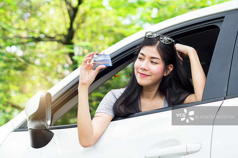 笑容满面的女士手持信用卡进行在线购物图片素材