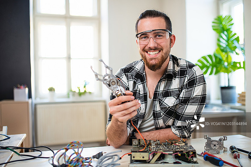 社区中心里装有机械手臂的年轻男人图片素材