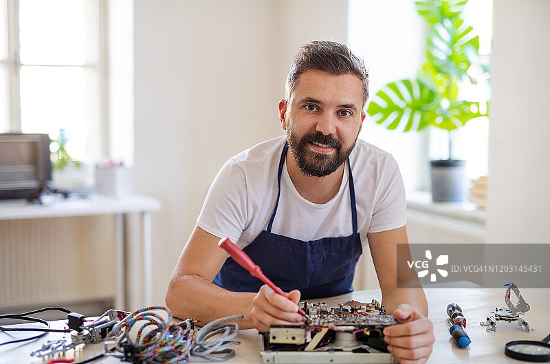 中年男人在社区中心修理家用设备图片素材