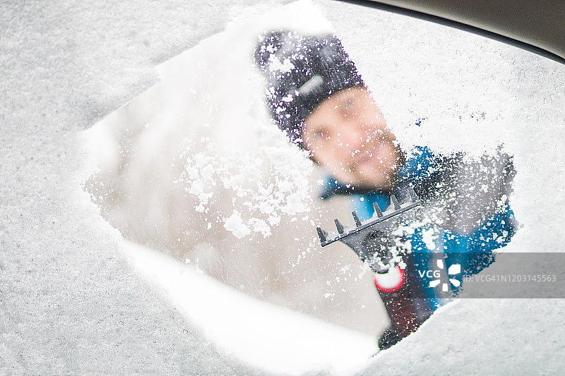 从车窗刮冰雪，男人正从车窗往外看图片素材