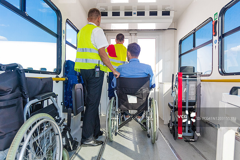 地勤人员在机场帮助残疾乘客登机图片素材