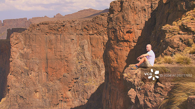 男人坐在山顶上看风景图片素材