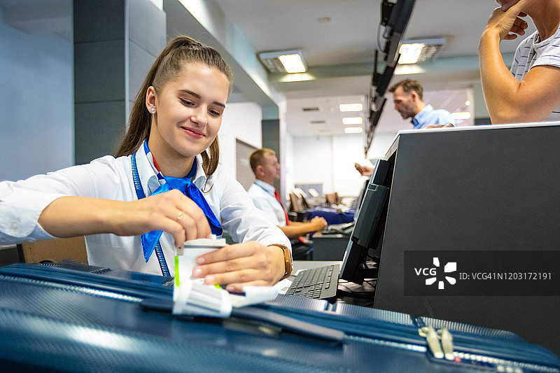 航空公司值机员在行李上贴标签图片素材