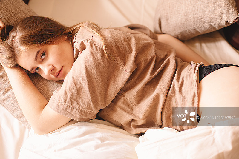 在家中床上躺着的年轻女子图片素材