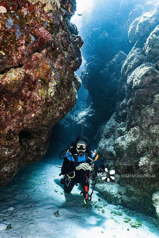 水肺潜水员在澳大利亚大堡礁探索峡谷图片素材
