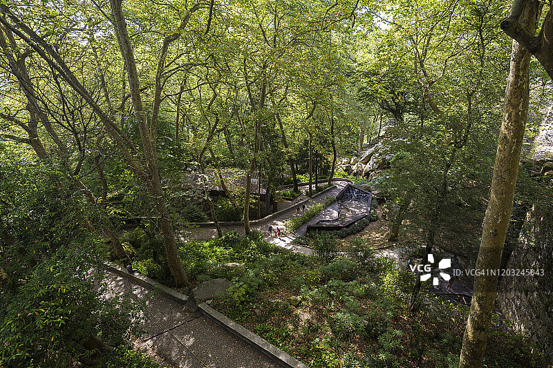 从上方俯瞰葡萄牙辛特拉郁郁葱葱的森林中通往摩尔人城堡的中世纪山顶城堡的步道图片素材