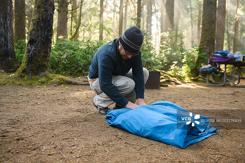 美国俄勒冈州森林营地里收拾帐篷的30多岁男人图片素材