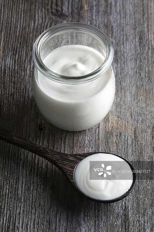木桌背景上的酸奶罐图片素材