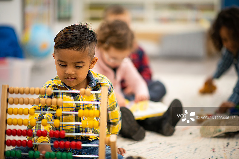 玩算盘的混血学龄前儿童图片素材