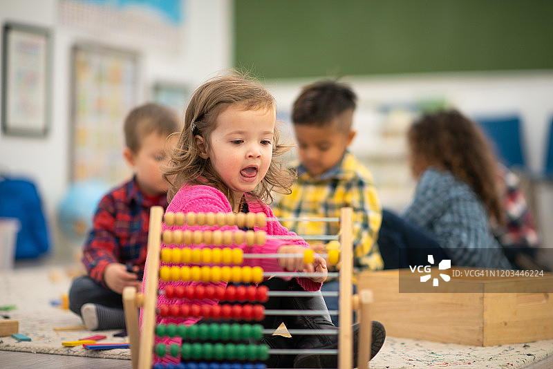 玩算盘的幼儿园女孩照片图片素材