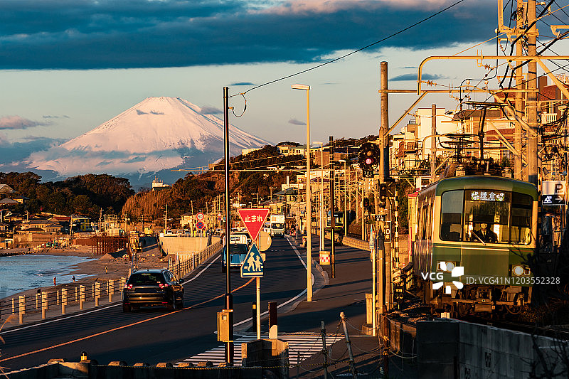 日本神奈川县的雪山富士山和沿海行驶的当地火车图片素材