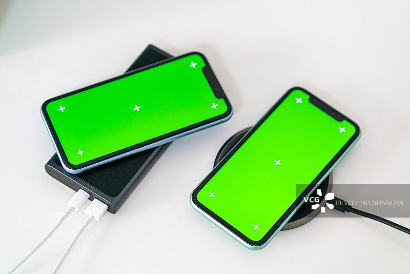 两部用无线充电器充电的手机图片素材