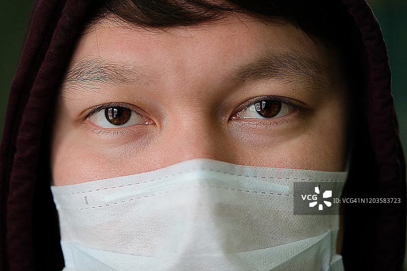 戴着头罩和医用口罩以保护自己免受冠状病毒侵害的亚洲男人。关于空气污染、肺炎爆发、流行病、生物危害病毒感染的概念图片素材