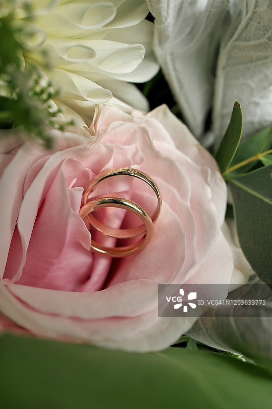金色结婚戒指与大丽花和玫瑰图片素材