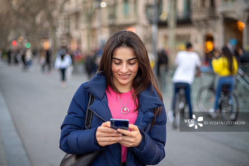 女人在城市中使用智能手机图片素材