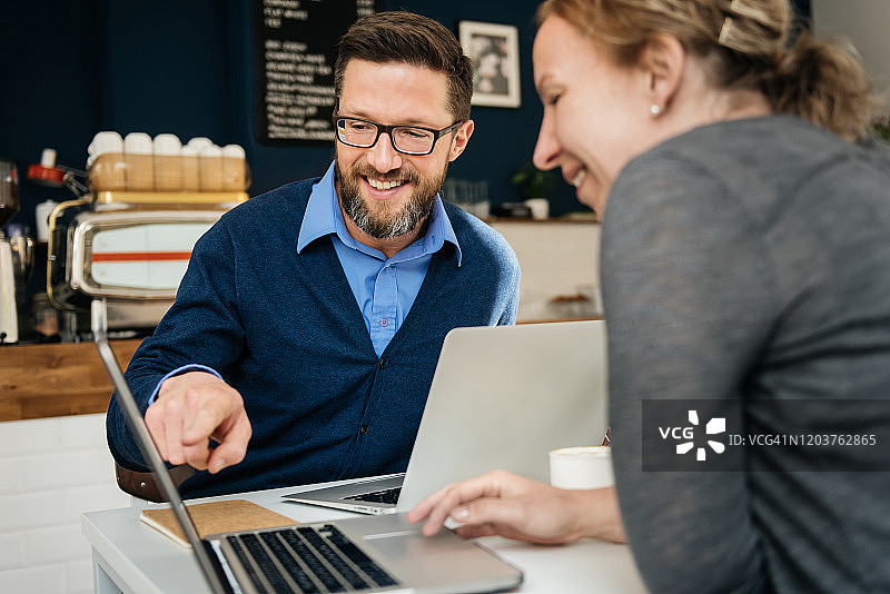 男子在笔记本电脑上向商业伙伴展示文件图片素材