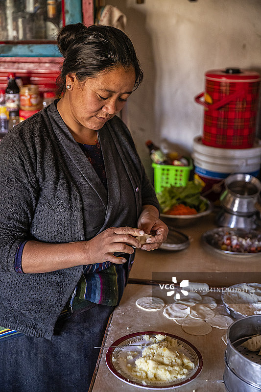 在尼泊尔木斯塘上部准备制作馍馍的藏族妇女图片素材