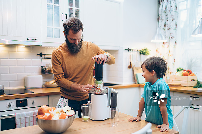 父子在家准备蔬菜汁图片素材