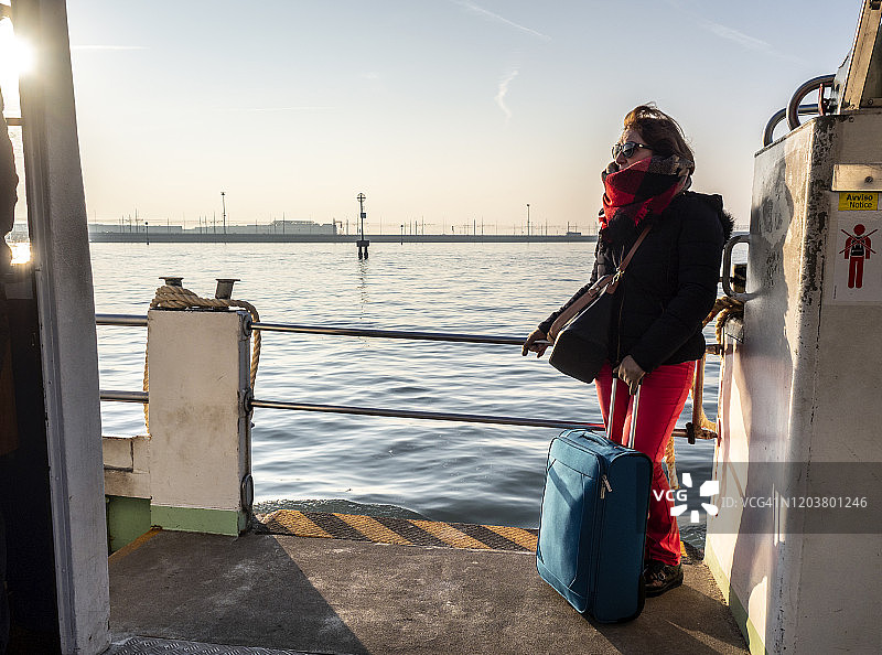 女游客带行李箱乘水上巴士游威尼斯图片素材