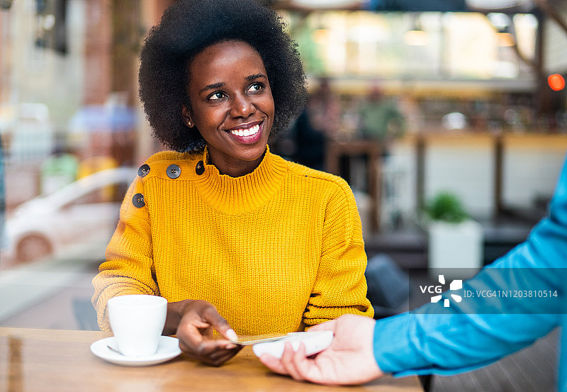 用信用卡进行非接触式支付的漂亮非洲裔美国女人图片素材