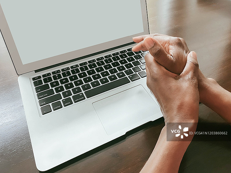 女人使用笔记本电脑，手部疼痛图片素材