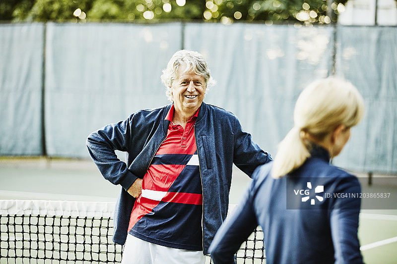 在清晨网球比赛前与妻子交谈的年长丈夫图片素材