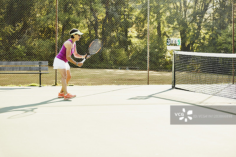 年长的女人在清晨的网球比赛中打球图片素材