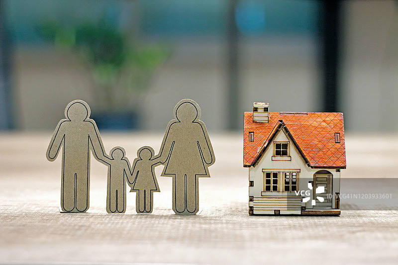 家庭生活可持续财务目标概念：桌上的家庭纸和房屋模型图片素材