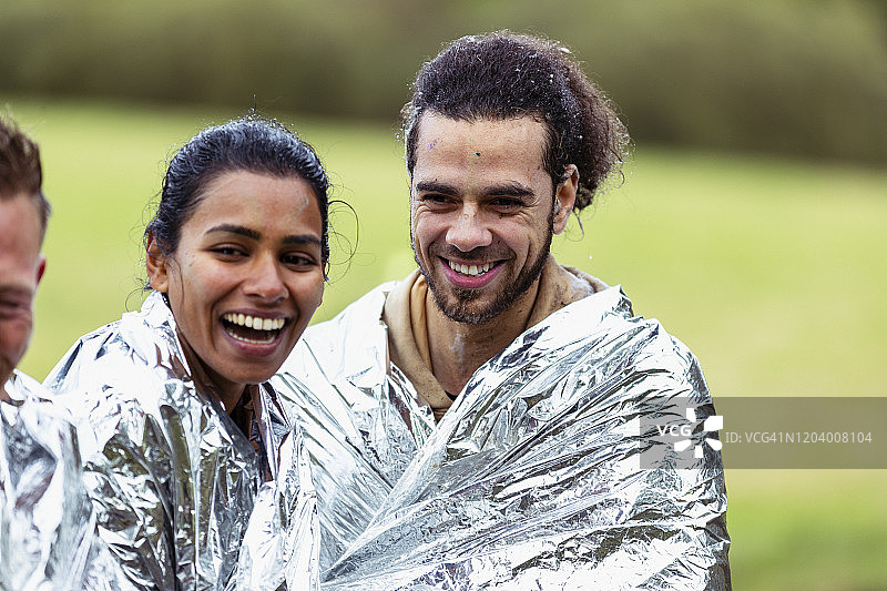 活动结束后裹着锡箔毯与朋友们一起欢笑的女人图片素材