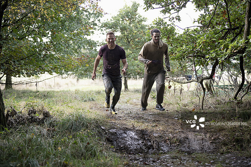 男性朋友一起沿着泥泞小路跑步图片素材