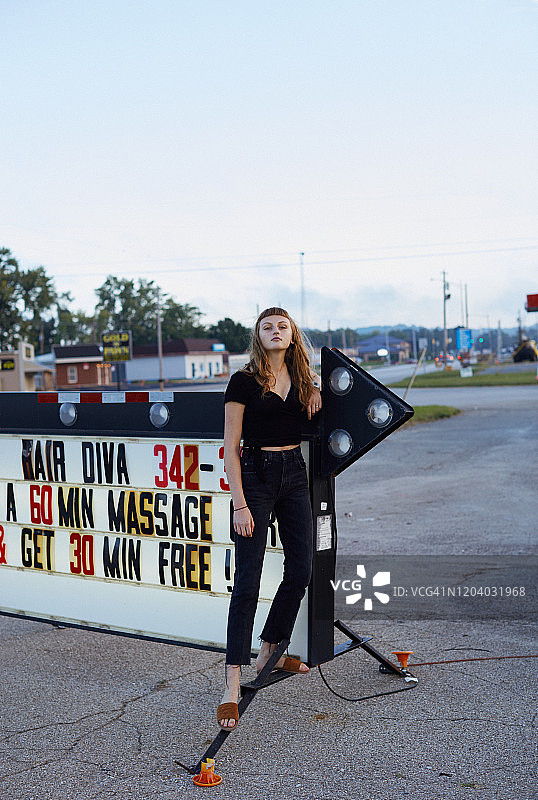 站在街头箭头标志上的少女全身像图片素材