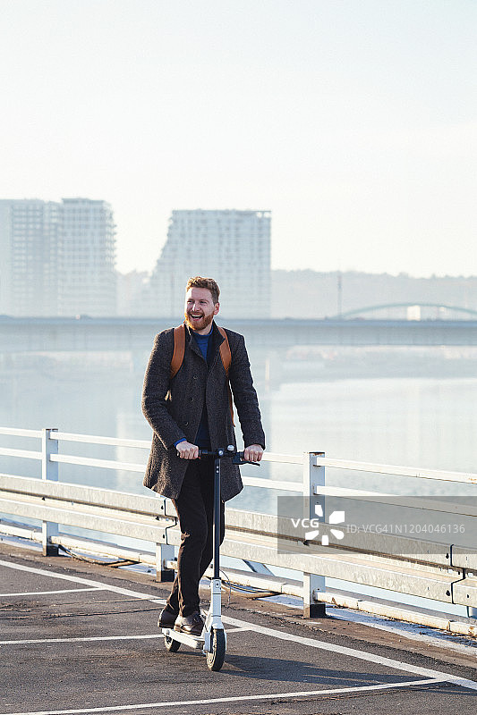 在城市里骑电动滑板车的年轻商人图片素材