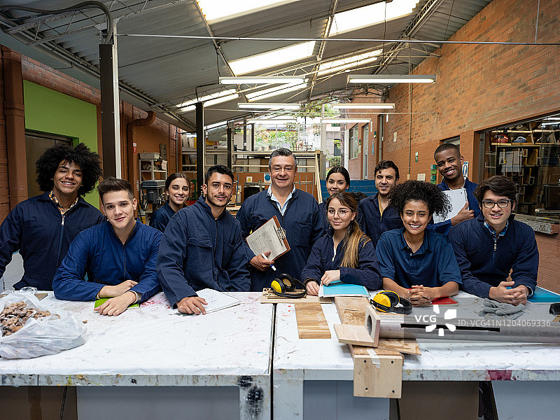 在工作室课堂上，快乐的老师与一群设计专业的学生在一起图片素材