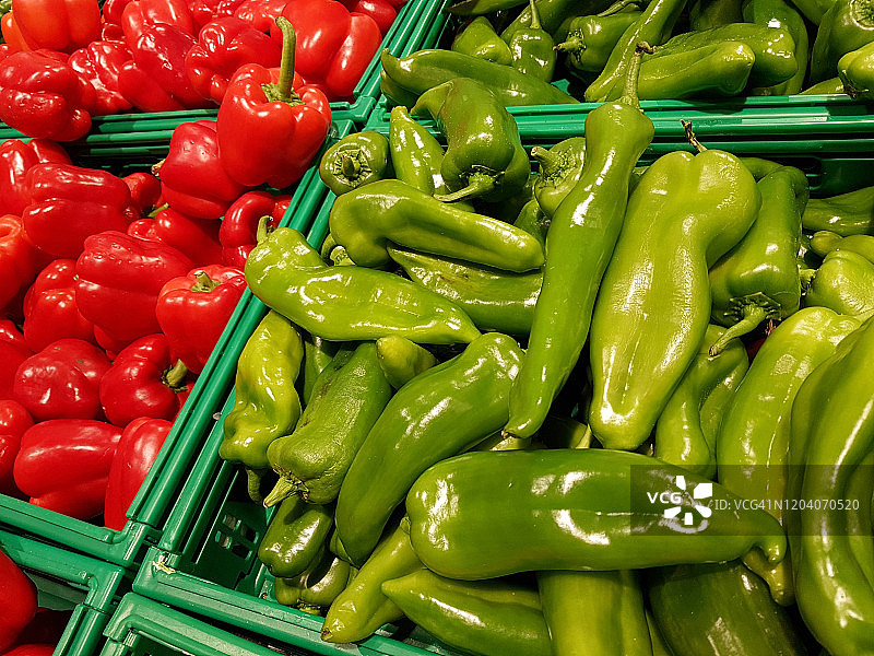 市场上巨大的绿色辣椒和红色甜椒图片素材