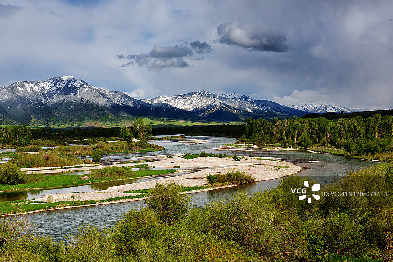 蛇河穿过山谷，远处是爱达荷州东部的雪 capped 蛇河山脉图片素材