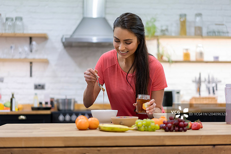 快乐的居家女人在家准备健康早餐图片素材