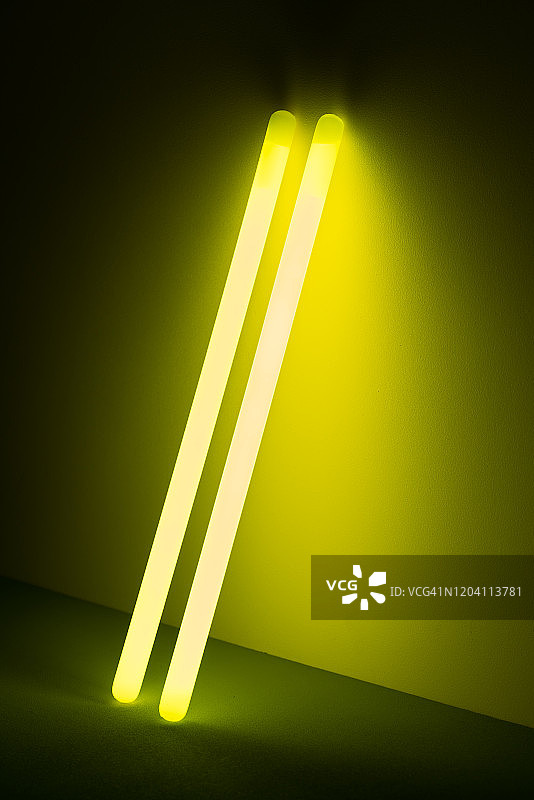 黑暗中两根黄色的荧光棒图片素材