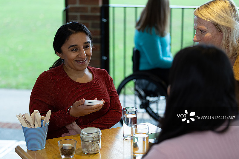 面带微笑的女服务员在咖啡厅与顾客交谈图片素材