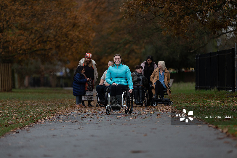 中年妇女坐在公园的轮椅上图片素材