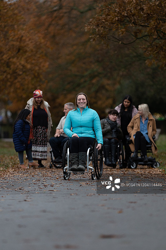 中年妇女坐在公园的轮椅上图片素材