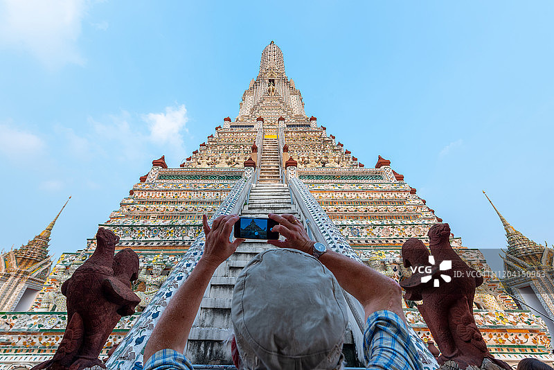 泰国阿伦寺旅行摄影曼谷概念。游客正在用智能手机拍摄黎明寺。黎明寺是曼谷重要的旅游景点，游客喜欢参观。图片素材