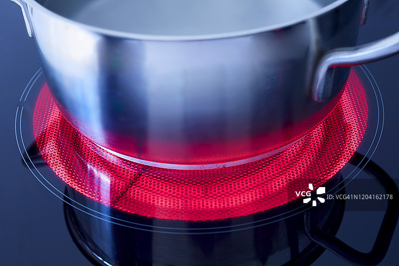 高角度拍摄：陶瓷炉灶上装有沸水的锅图片素材